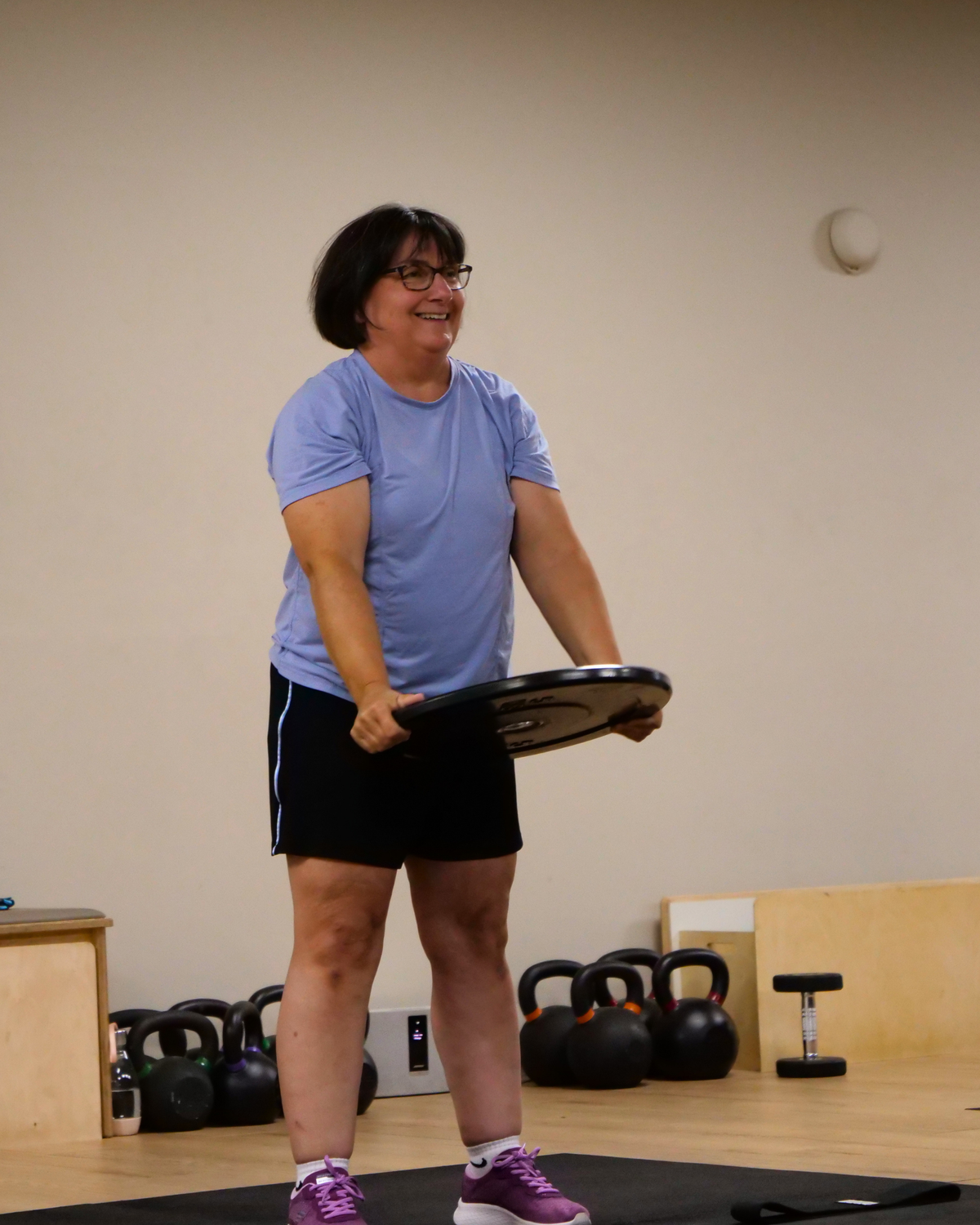 Insidesweat strength training studio in Cheltenham, Gloucestershire, with older adults training with dumbbells and kettlebells